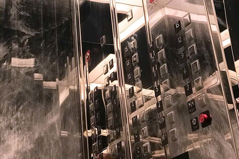 Chanel NYC Headquarters mirrored cab interior reflecting elevator call buttons into infinity